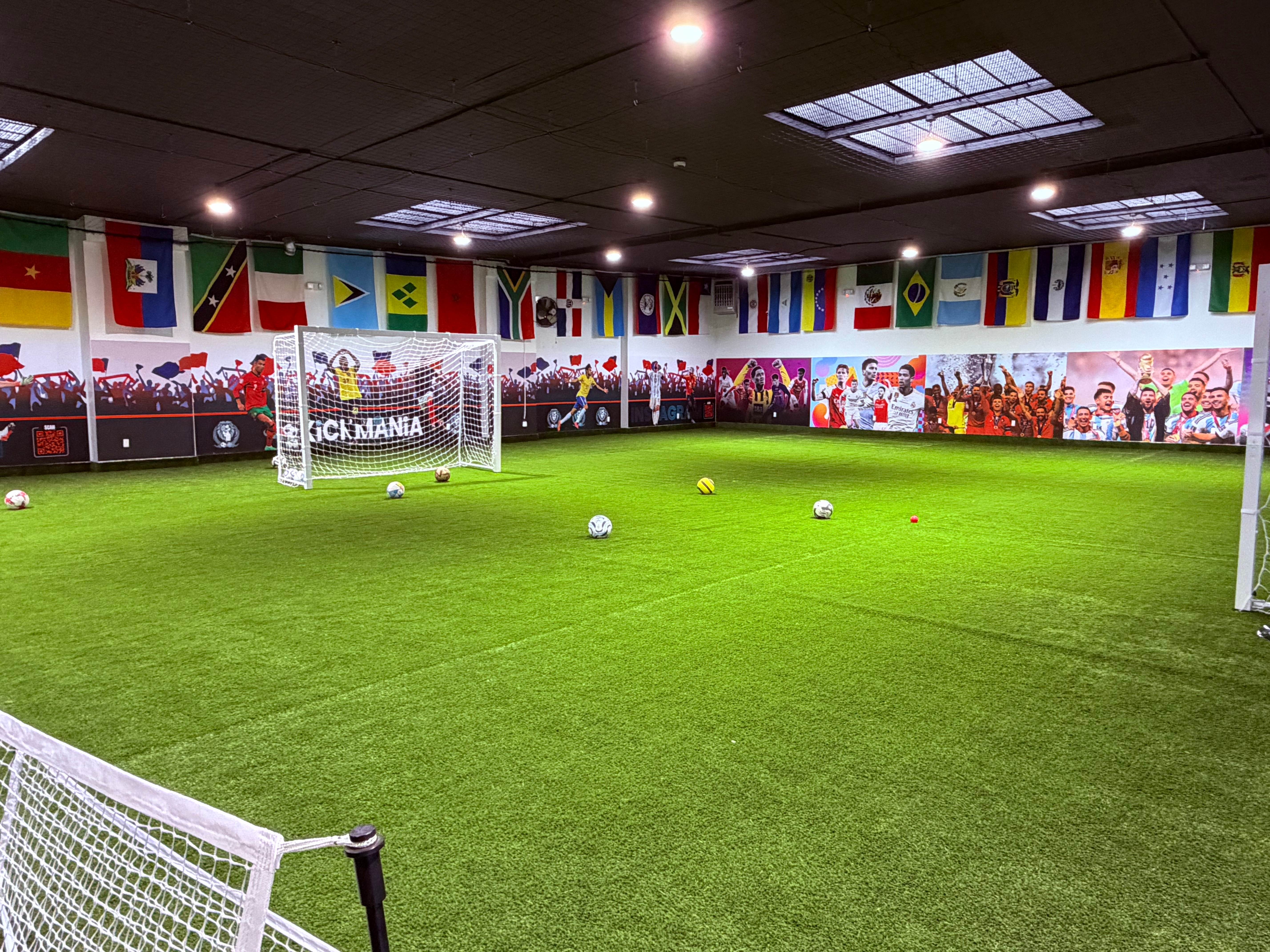 Wide view of the indoor futsal field with international flags and player murals