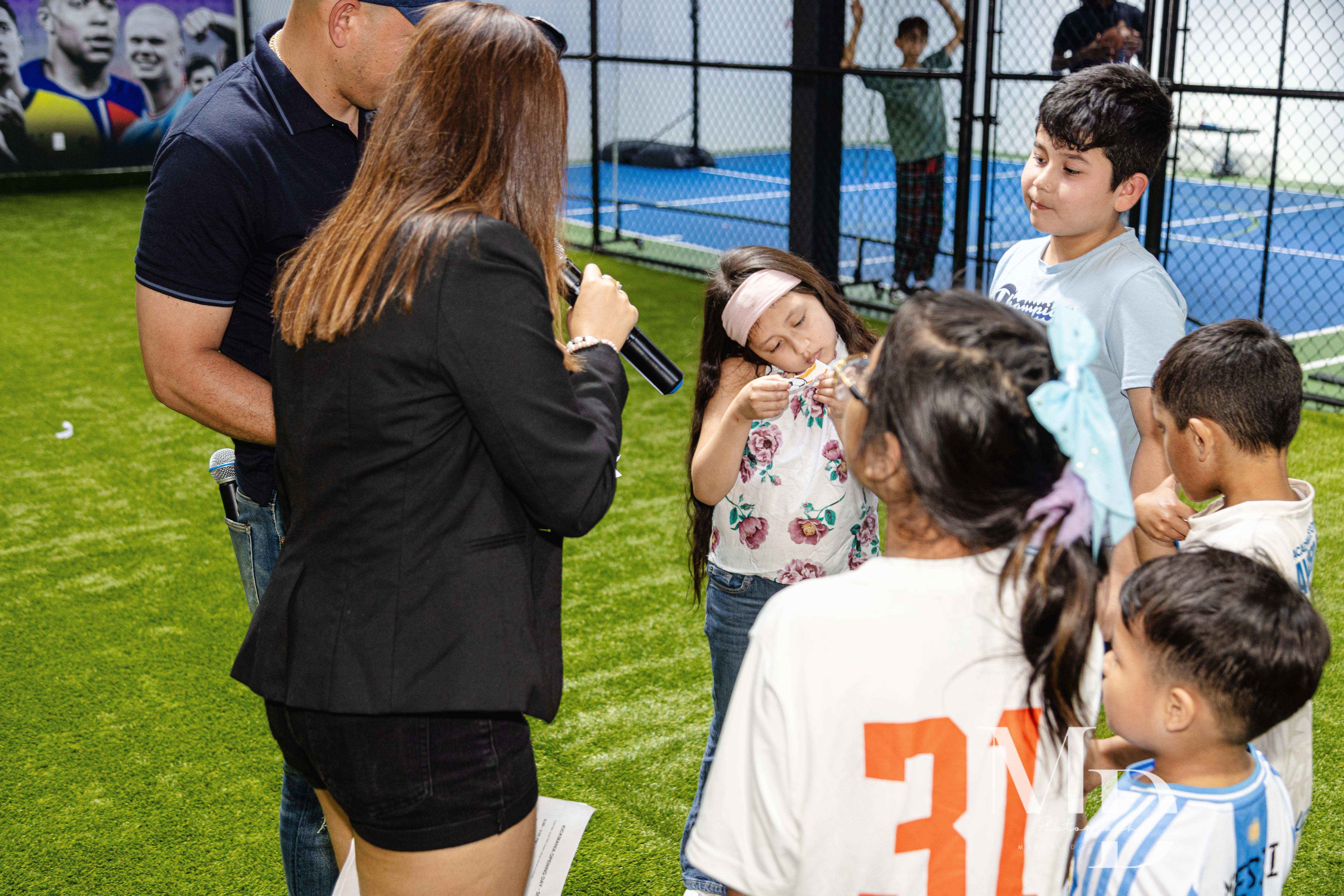 Kids receiving medals at a Kickmania event on the turf field