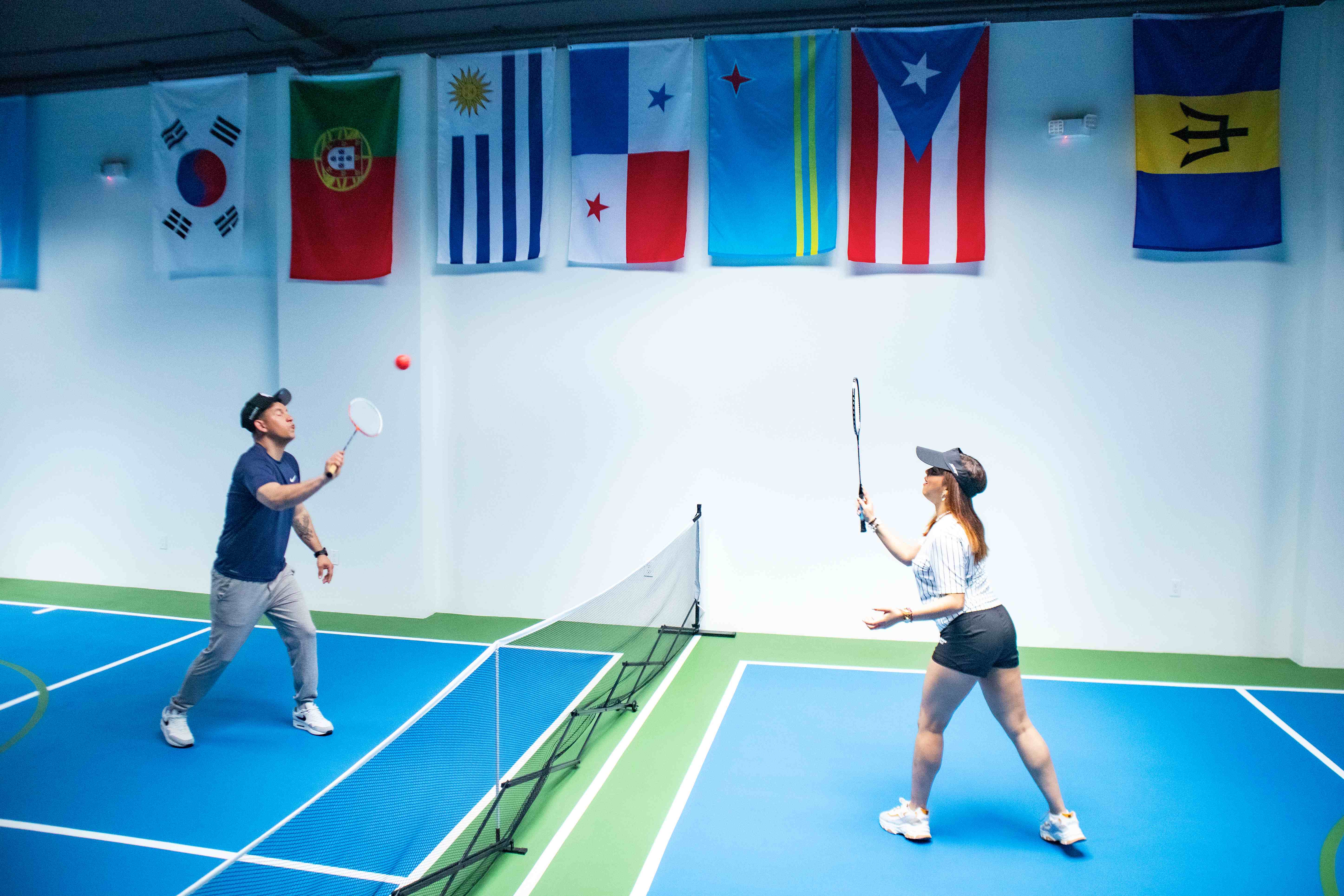 Two players rallying across the net on the pickleball court